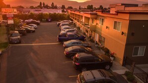 Un estacionamiento con varios coches aparcados frente a un edificio con un letrero que dice 'Sahara Court Yard Inn'.