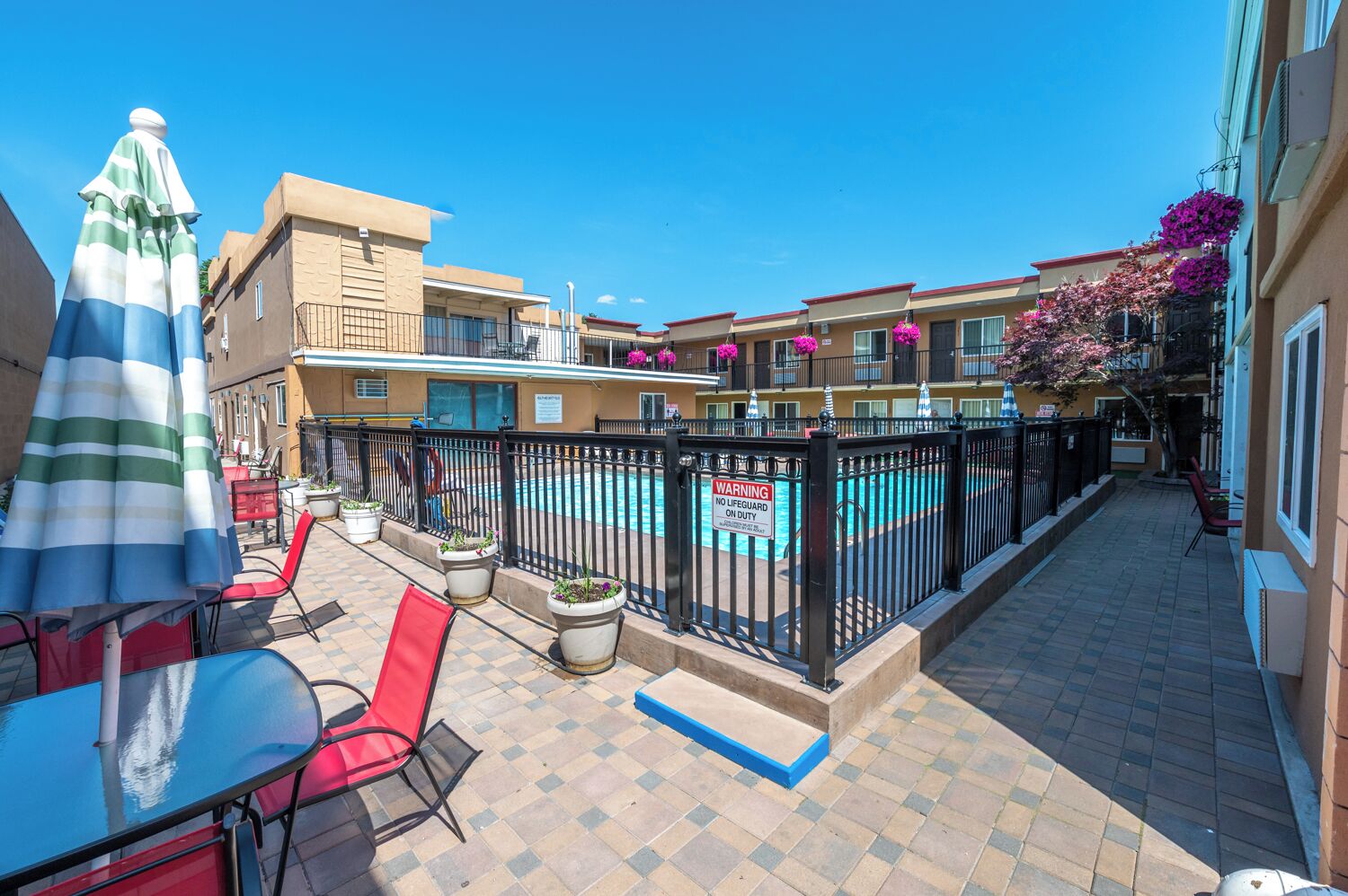 A courtyard with a pool, outdoor seating, and a warning sign.