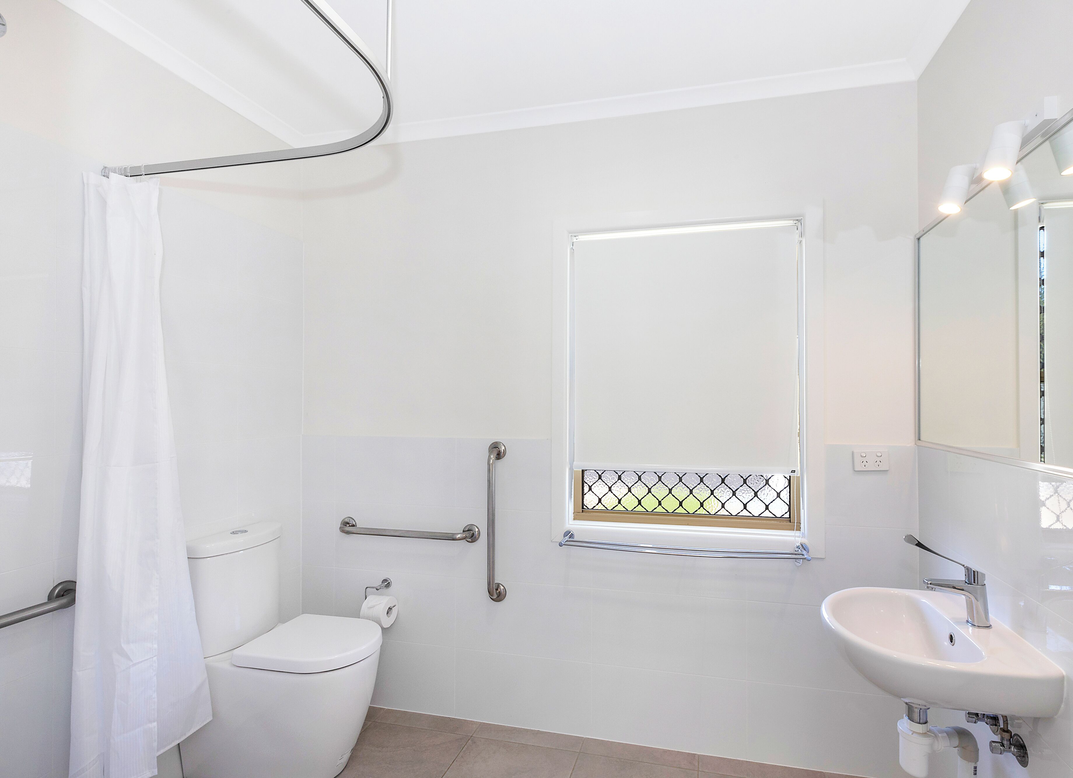 A modern bathroom with a toilet, a sink, and a shower area.