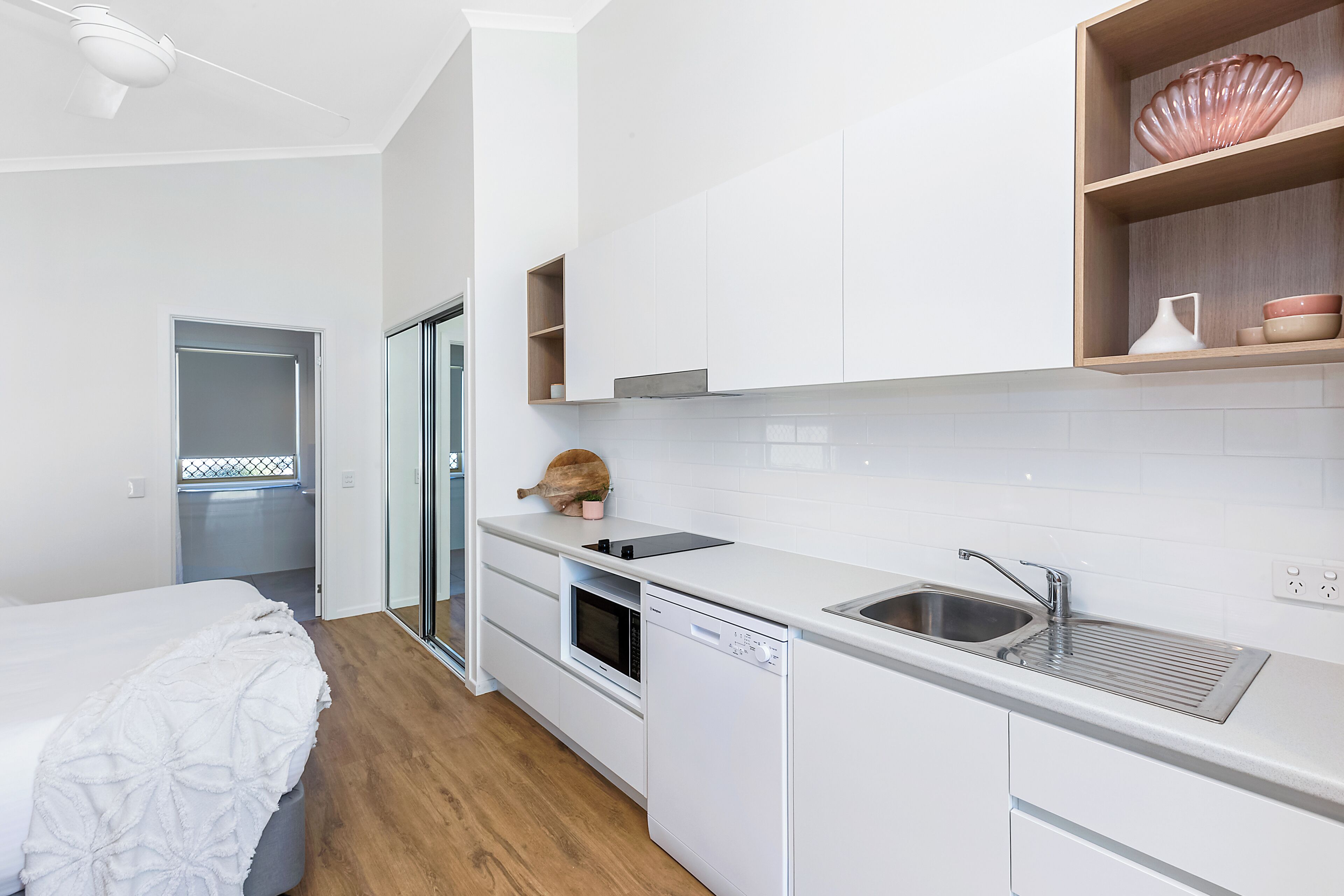 A modern kitchen with white cabinetry, a built-in oven, and a dishwasher.