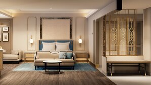 A hotel room with a bed, a sofa, a small table, a desk, and a wardrobe. - Grand Hotel Preanger, Bandung, a Tribute Portfolio Hotel (Bandung)