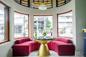 A corner seating area with a round table and red upholstered benches.