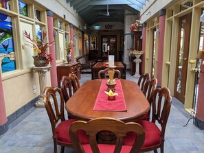A dining area with a long table, chairs, and a red runner. - Ettalong Beach Tourist Resort (Ettalong Beach)