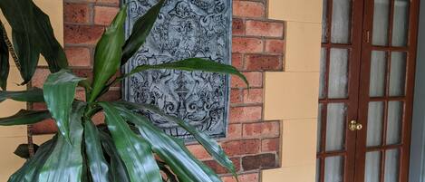 A brick wall with a decorative metal plate and a door with glass panels.