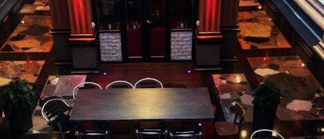 A spacious lobby with a central wooden reception desk, multiple seating areas, and a patterned floor.
