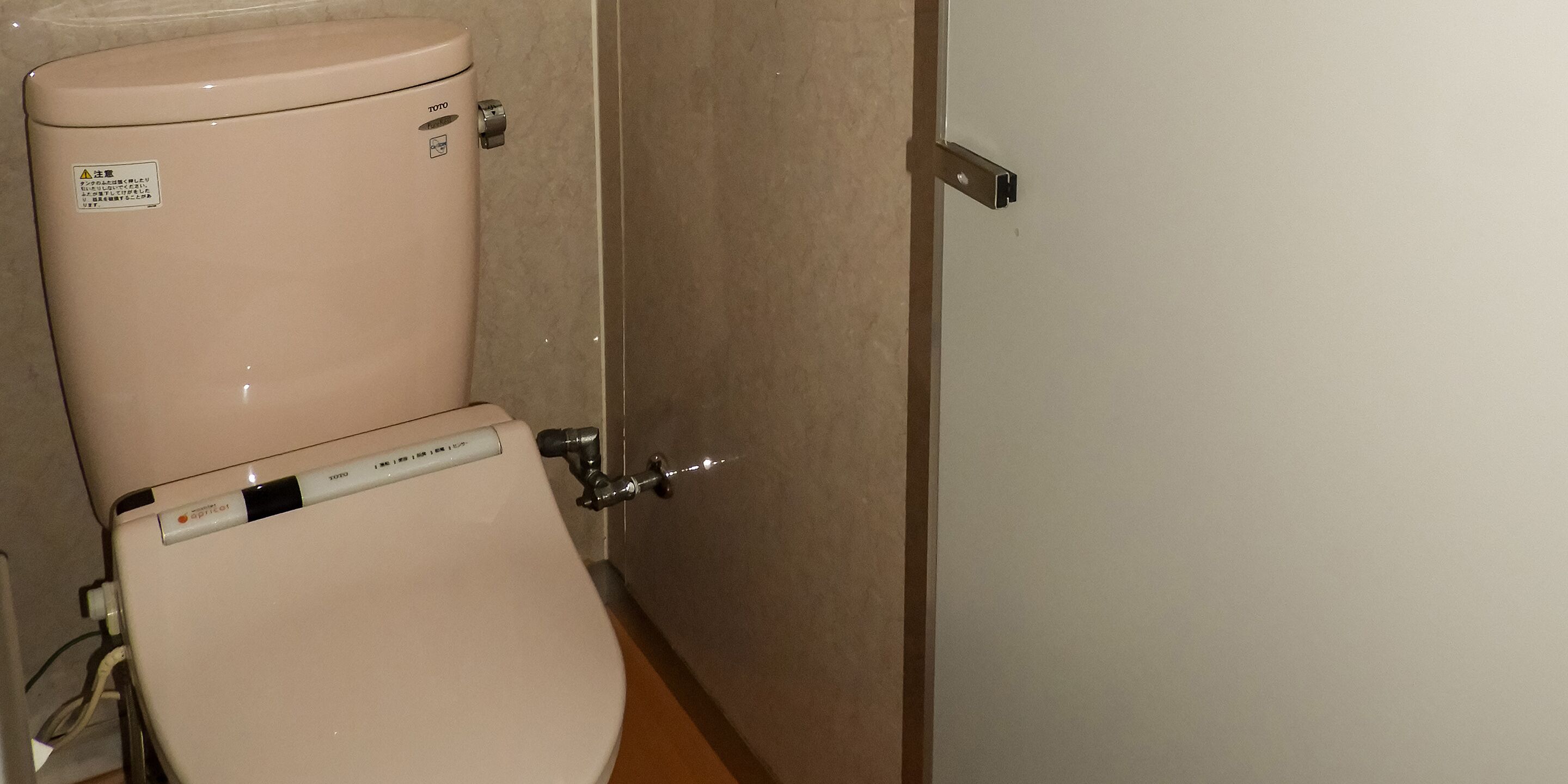 A toilet with a control panel and a flush handle.