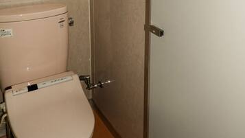 A toilet with a control panel and a flush handle.