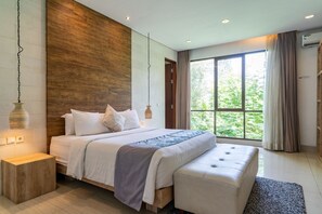 Een moderne slaapkamer met een groot bed, nachtkastjes, een bankje en uitzicht op groen door het raam.