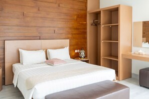 Un dormitorio moderno con cabecera de madera, una cama grande con ropa blanca, una mesita de noche con lámpara y un armario empotrado.