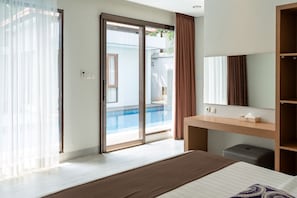 A hotel room with a bed, a bedside table, a mirror, a sliding glass door leading to a pool area. - Kirei Mountain View Villa 7 Br With Heated Pool (Bandung)
