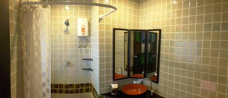 A bathroom with a shower, a sink, and a mirror.