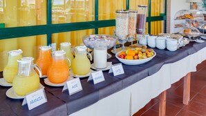 A buffet with labeled beverage dispensers and a fruit bowl. - Villaggio Mare Si (Follonica)