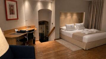 Ein Hotelzimmer mit Bett, Schreibtisch, Stuhl und einer Treppe.