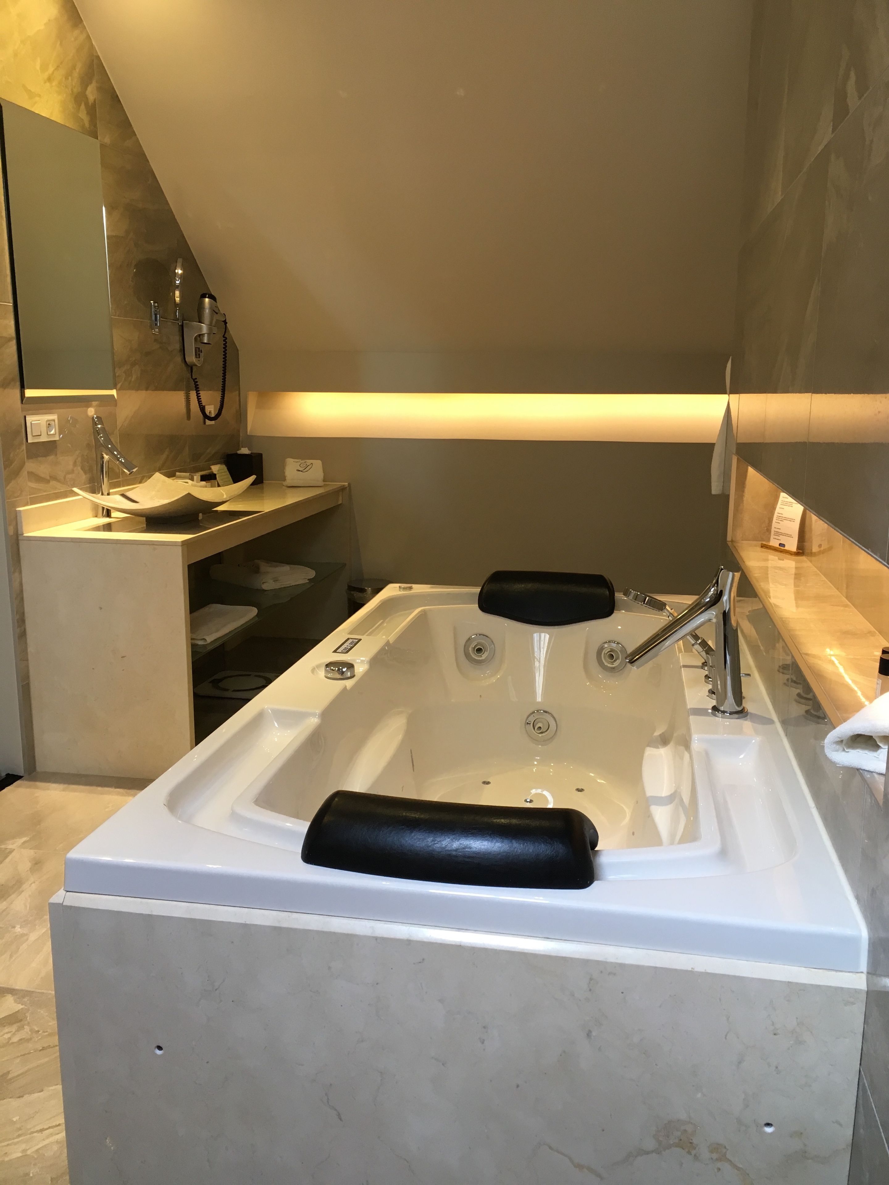 A modern bathroom with a freestanding bathtub, a vanity with a mirror, and a towel rack.