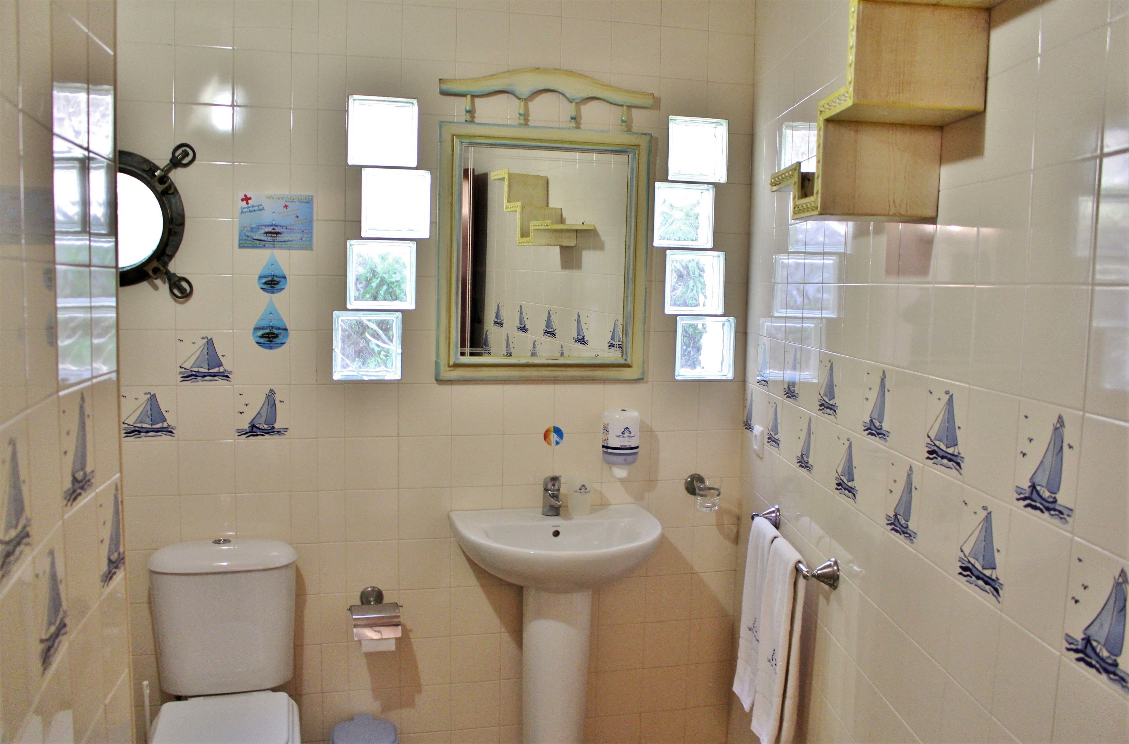 A bathroom with a toilet, sink, and mirror.