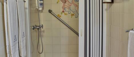 Un bagno con doccia, servizi igienici e una parete decorata con piastrelle.