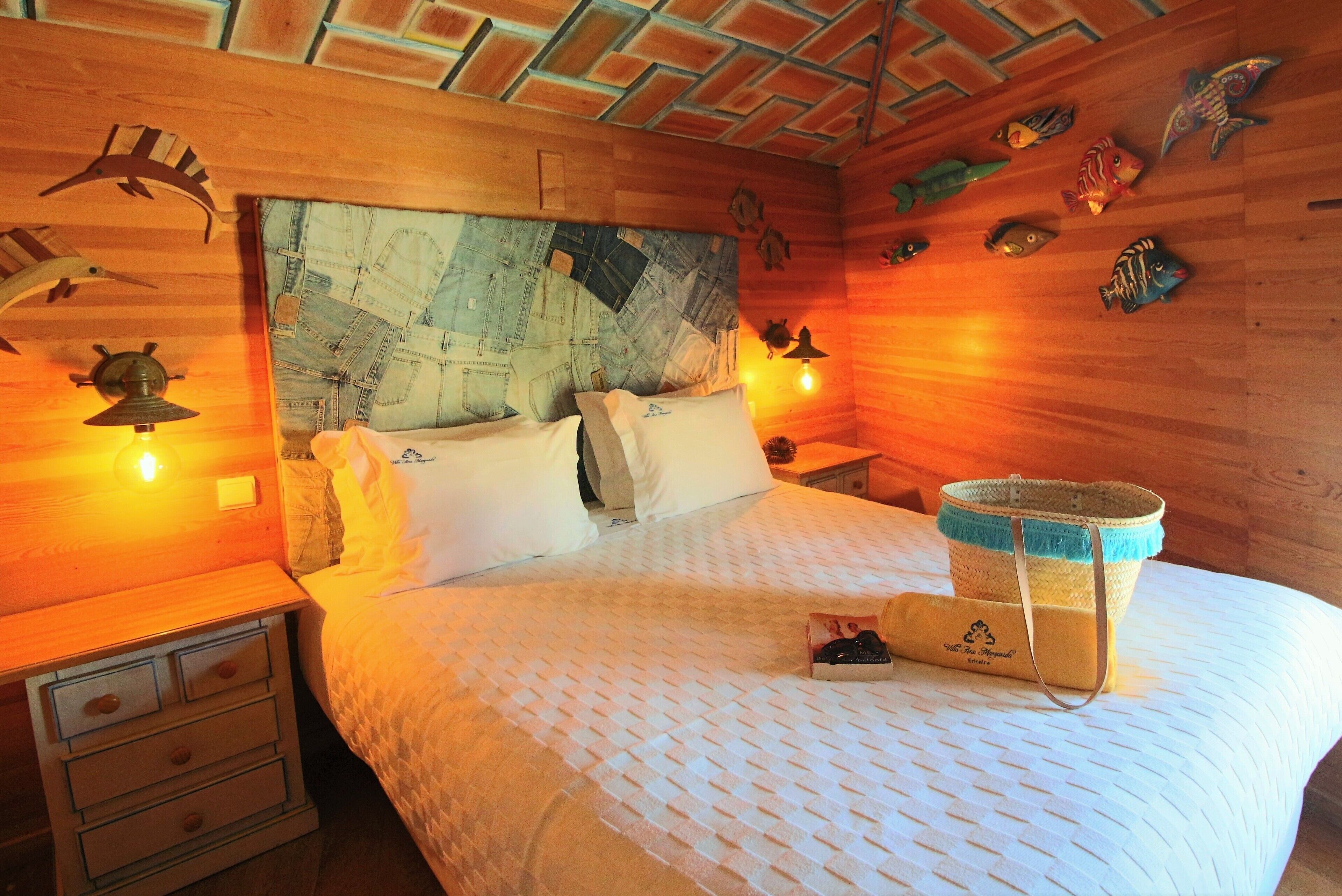 Una habitación con una cama, paredes de madera y decoración con peces.