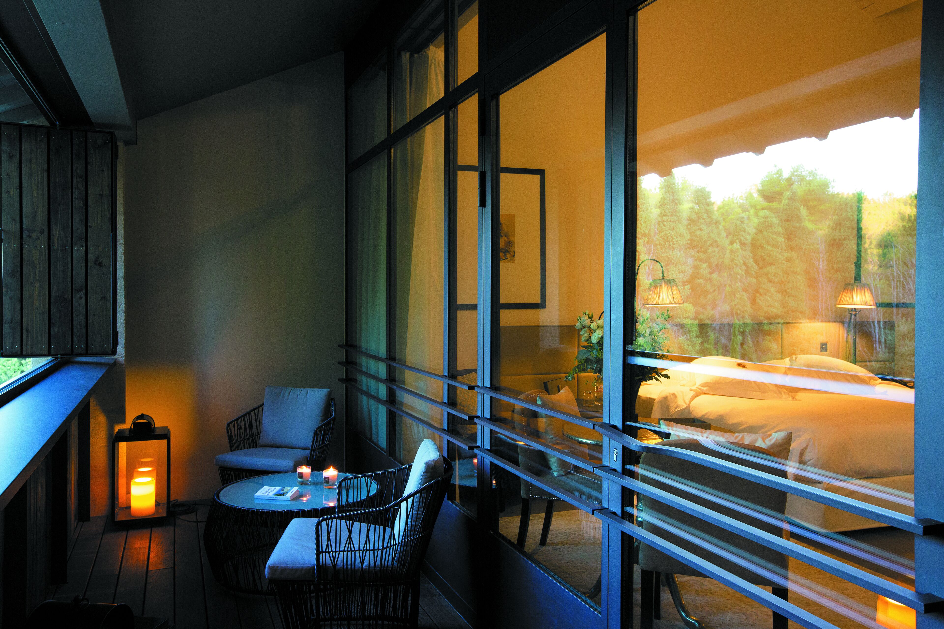 A balcony with a table, chairs, and a candle.