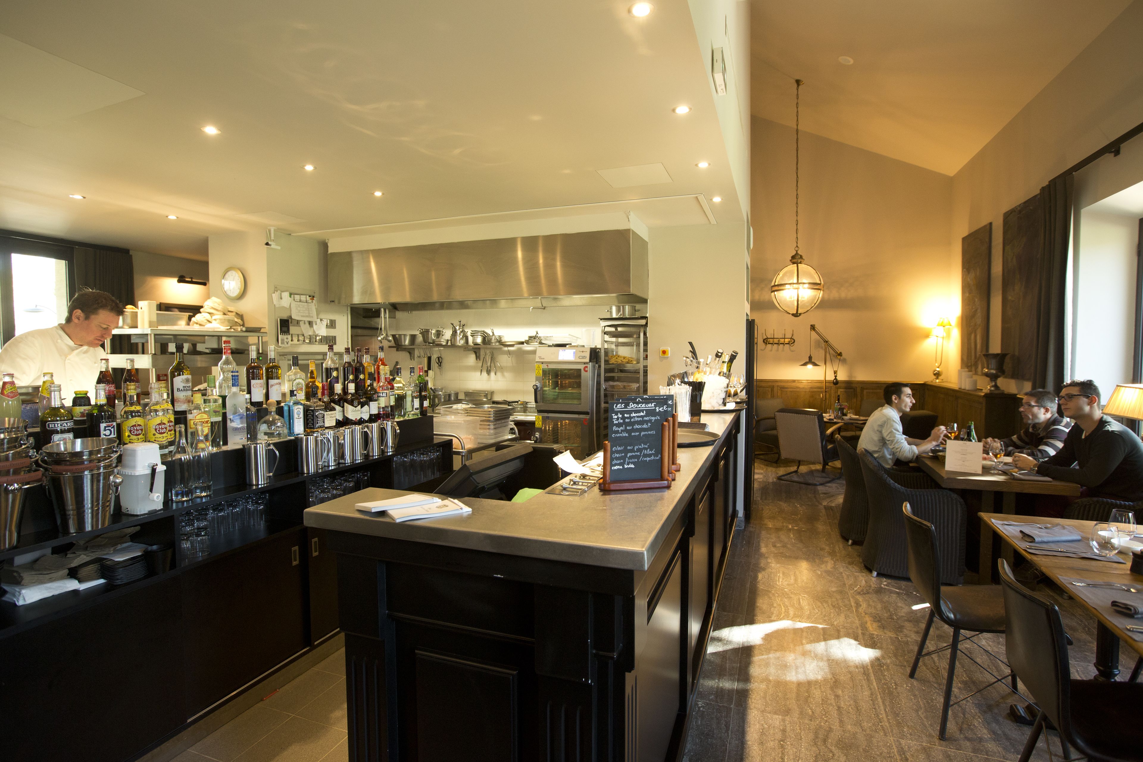 A modern bar area with a counter, bar stools, and a seating area with tables and chairs.