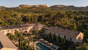 Un grand bâtiment doté d’une piscine, entouré d’arbres et de collines.