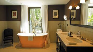 Un bagno con una vasca freestanding, un mobile lavabo doppio e uno specchio grande.