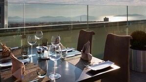 A dining table set for two with a view of the sea and mountains. - Dedeman Bostancı (Istanbul)