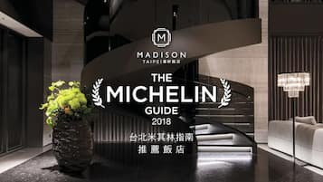 Een modern interieur met een groot bord waarop 'Madison Taipei Madison Restaurant' en 'De Michelin Gids 2018' staat.