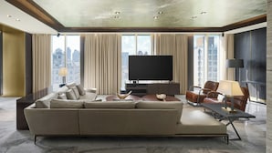 A modern living room with a large sofa, a flat-screen TV, and a city view through large windows. - Madison Taipei, a Tribute Portfolio Hotel (Taipei)