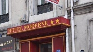Ein Gebäude mit roter Fassade und einem Schild mit der Aufschrift 'HOTEL MODERNE'.