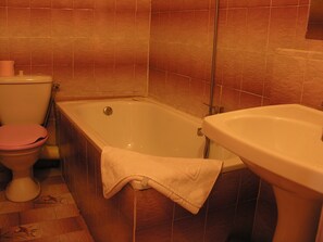 Un baño con bañera, inodoro y lavamanos.
