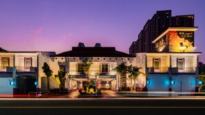 Un hotel con fachada tradicional, un cartel llamativo del Motel Li Ti y una entrada bien iluminada con un pequeño jardín.