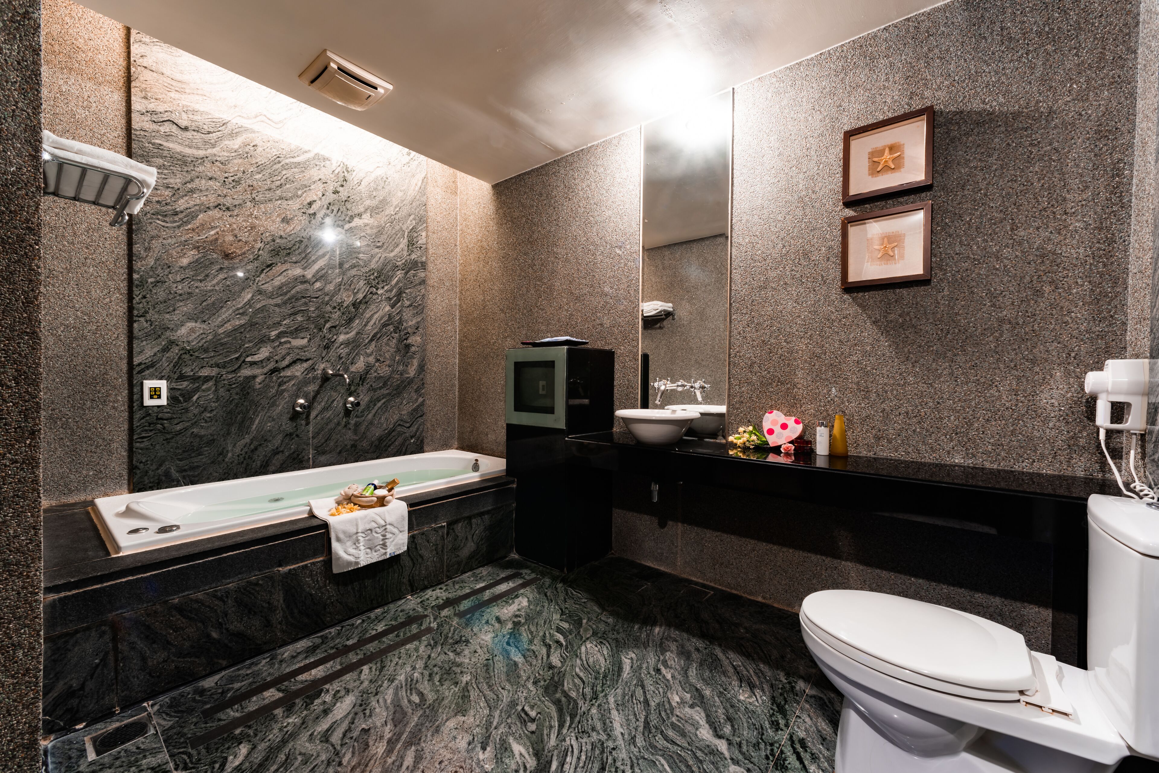 Un baño moderno con lavamanos de mármol, bañera y retrete.