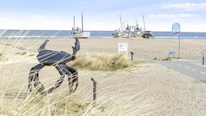 A beach with fishing boats, a road, and a signpost. - Rønnes Hotel (Fjerritslev)