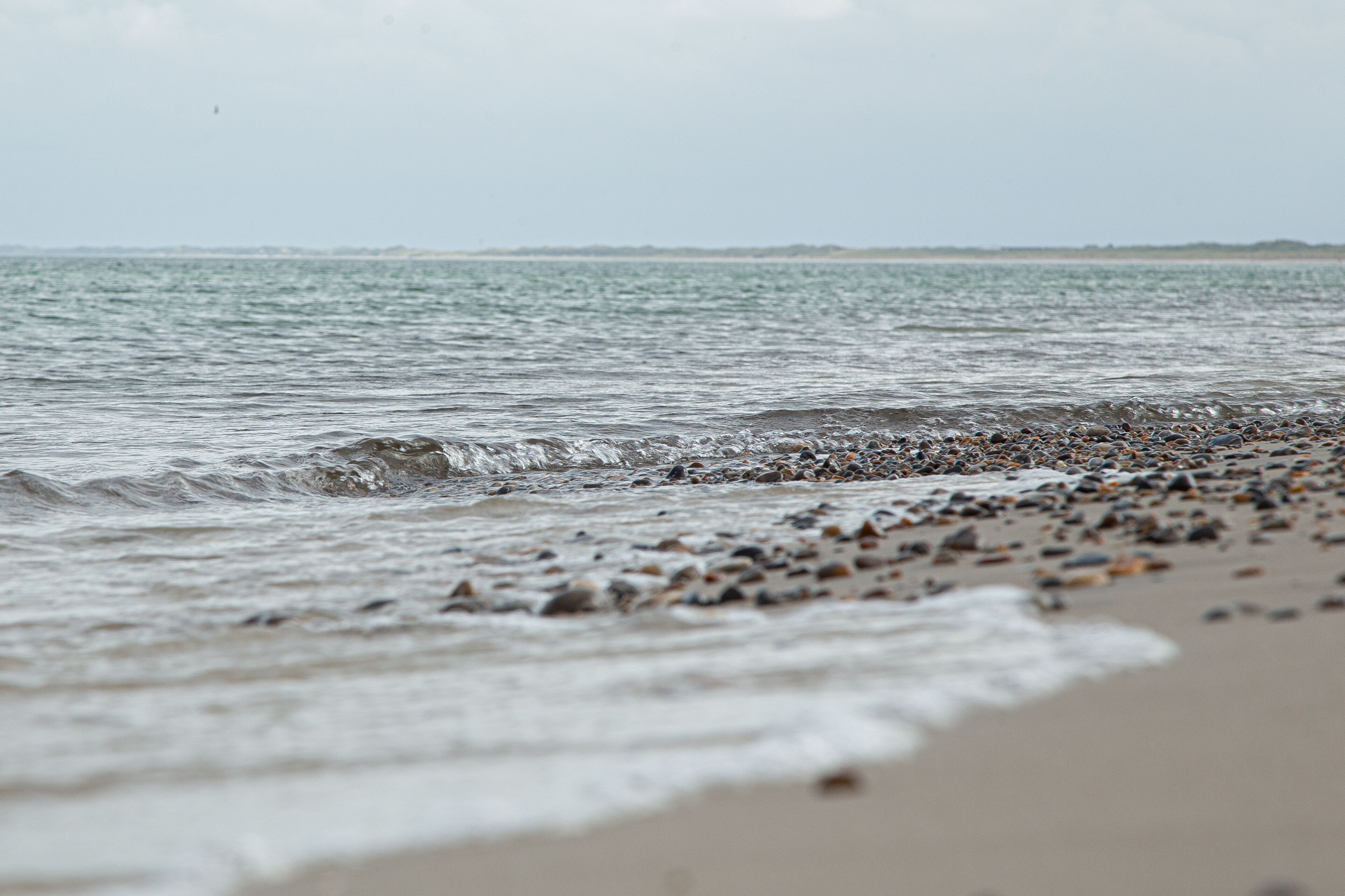 Una playa con piedras y olas.