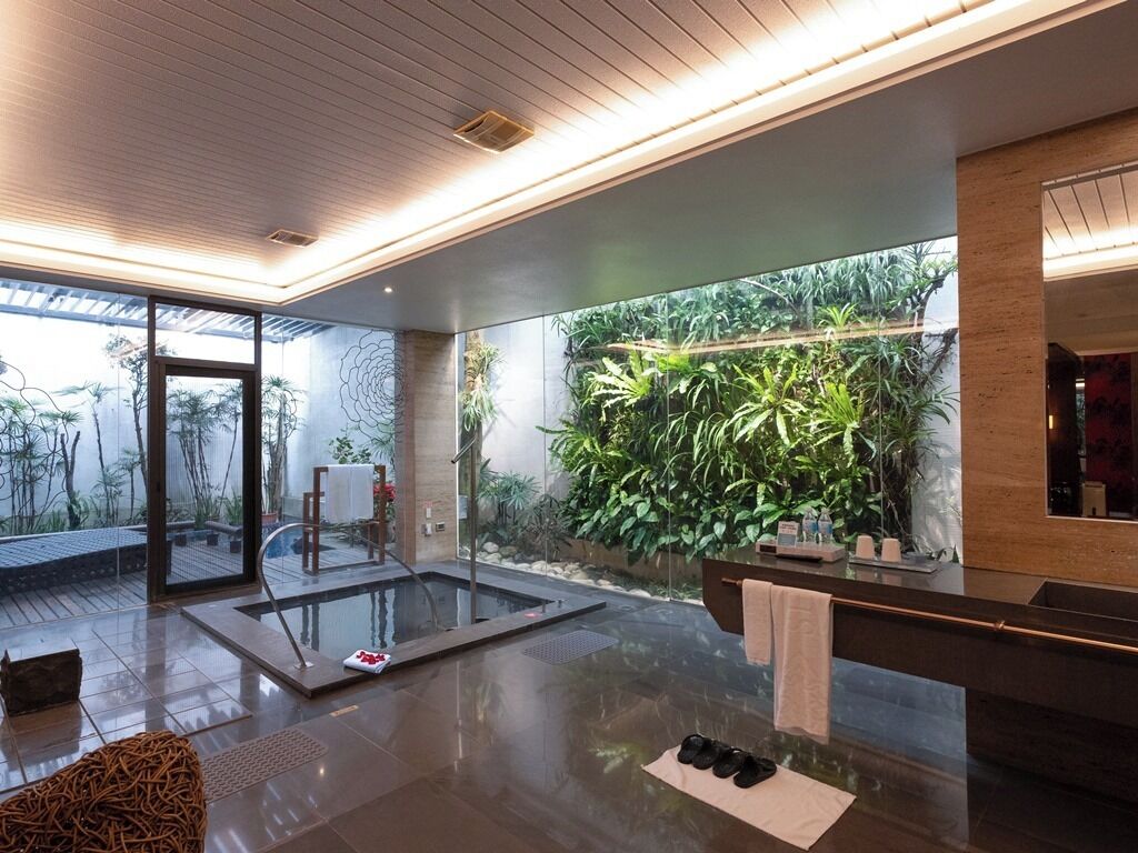 A modern bathroom with a glass shower, a large mirror, and a wall-mounted sink.