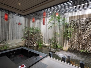 A spa area with a hot tub, bamboo plants, and a stone wall. - Mulan Boutique Hotel - Taichung Branch (Taichung)