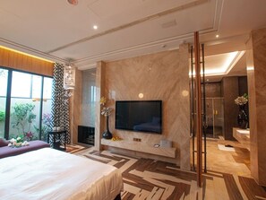 A modern hotel room with a large bed, a flat-screen TV mounted on a marble wall, a glass shower enclosure, and a view of the outdoors. - Mulan Boutique Hotel - Taichung Branch (Taichung)