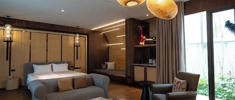 Une chambre moderne comprenant un lit, un canapé, un fauteuil et une table à manger.