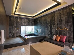 A modern bathroom with a bathtub, a vanity, and a seating area with a bench and pillows. - Mulan Boutique Hotel - Taichung Branch (Taichung)