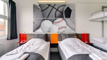 Two single beds with white bedding and grey headboards, complemented by a striking abstract artwork above.