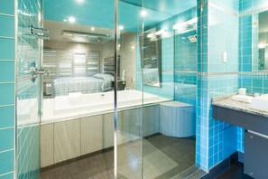 Une salle de bain moderne avec une douche à parois de verre, une grande baignoire et un meuble-lavabo avec un miroir.