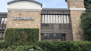 A building with a stone facade, a large metal gate, and the name "LECHABROL" on the wall. - Le Chabrol Hotel & Suites (Montreal)