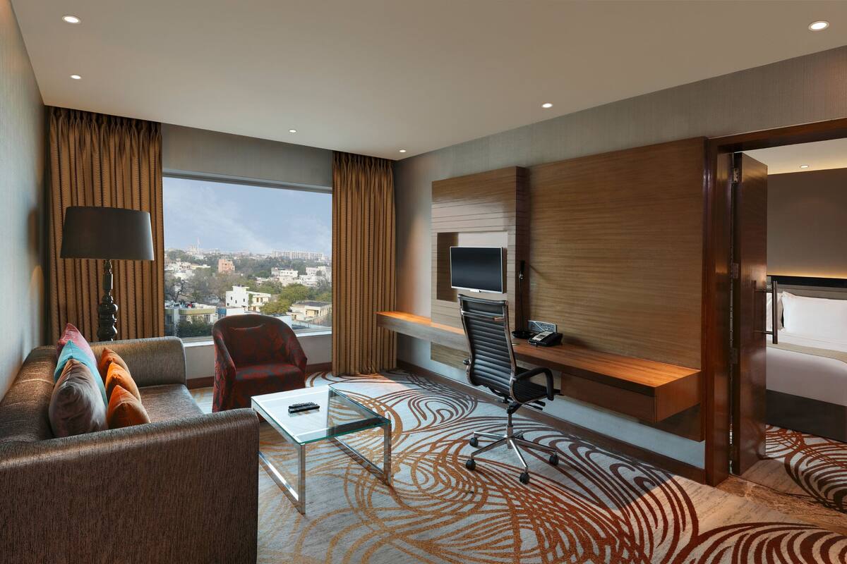 Ein Hotelzimmer mit einer Couch, einem Sessel, einem Schreibtisch und einem Bett.