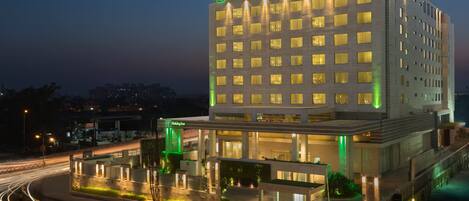 A Holiday Inn hotel with a modern design, featuring multiple floors and a well-lit facade.