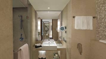 Un baño moderno con ducha, dos lavamanos, un espejo y un teléfono.