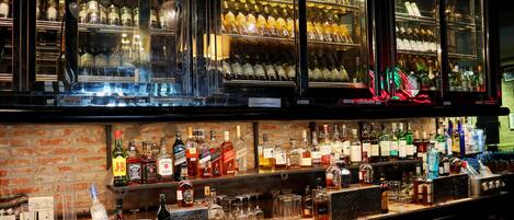 Eine Bar mit Regalen voller Spirituosenflaschen, Gläsern und einer Kasse.