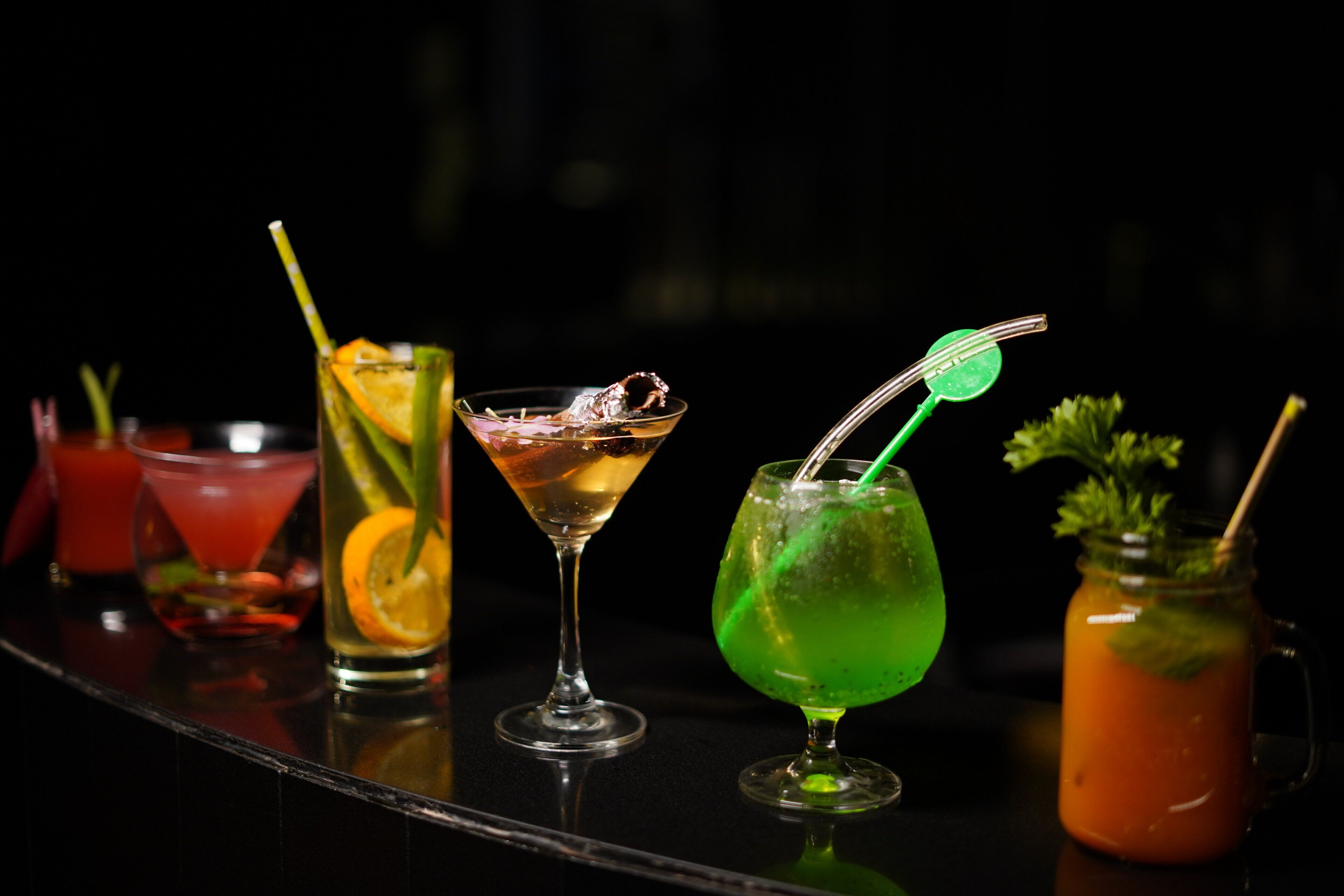 Un assortiment de cocktails présentés sur le comptoir d’un bar.