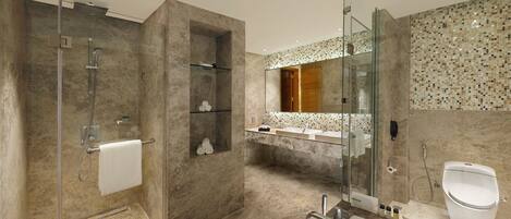 A modern bathroom with a glass-enclosed shower, a large bathtub, and a vanity with a mirror.