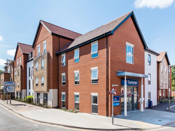 A Travelodge hotel with a brick facade, multiple windows, and a reception area. - Travelodge Chertsey (Chertsey)
