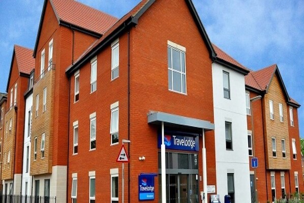 A Travelodge hotel with a red brick facade, multiple windows, and a signboard. - Travelodge Chertsey (Chertsey)